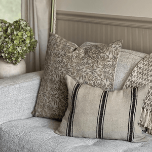 Elain and Maverick Lumbar on a grey sofa