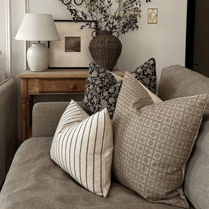 Felix, Georgia, and Winston Lumbar on a taupe couch in a living room.