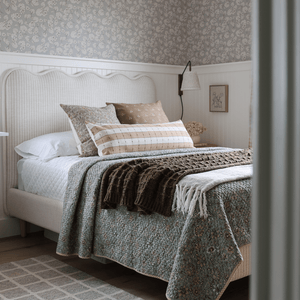 Prescott, Elain, and Emberly on a bed with a white headboard and a blue and brown blanket