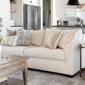 A cream couch with 5 Colin + Finn pillows - Royce Lumbar, Waylon, Penelope, Bardot, and Delilah