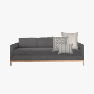 Alice pillow combo on a dark gray sofa with a white background.