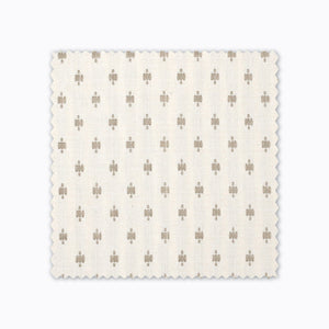 Elodie fabric swatch from Colin and Finn. Small gold crosses on a cream background