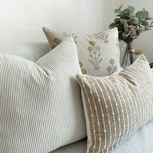 Felicity pillow combination from Colin and Finn on white sofa with floral arrangement on side table.