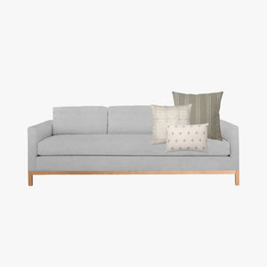 Colin and Finn's Hawthorn pillow combination on a light gray sofa.
