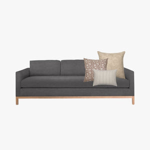 Mockup of Spencer Combo with Weston, Eleanor (natural), and Winston lumbar pillow cover from Colin and Finn on dark gray sofa.