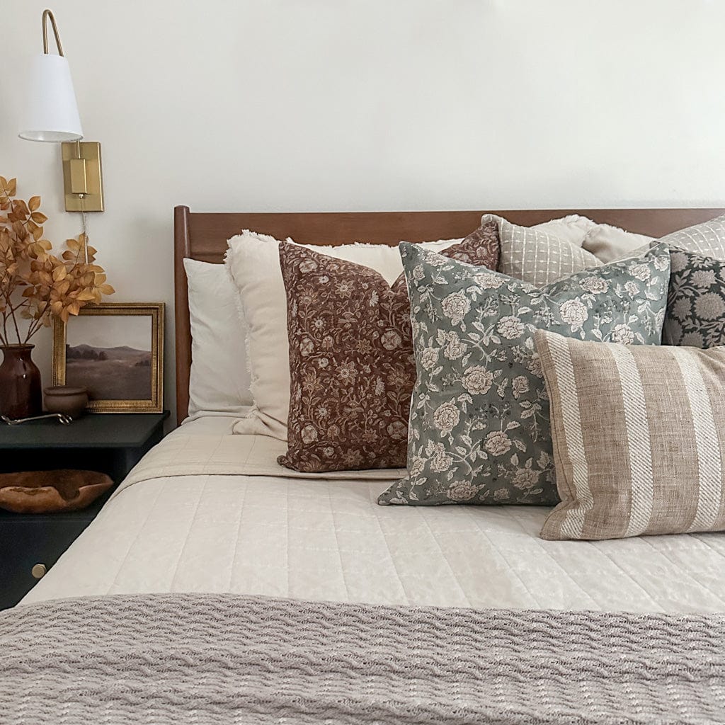 Agnes, Lenora, Esme, Callum, and Caspian lumbar pillow covers set on a beautiful bed with white quilt and beige throw blanket.