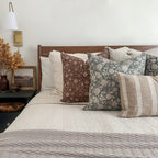Agnes, Lenora, Esme, Callum, and Caspian lumbar pillow covers set on a beautiful bed with white quilt and beige throw blanket.