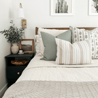 Colleen, Leighton, and Odin lumbar pillow covers on bed with white quilt and side table with minimalist home decor.