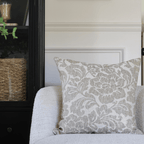 Delsi on a cream chair with a black bookcase in the background