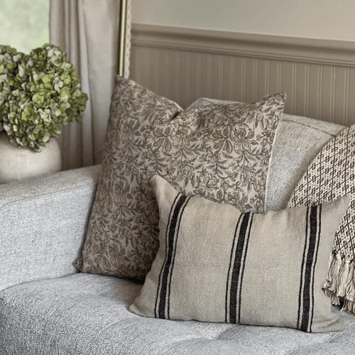 Elain and Maverick Lumbar on a grey sofa