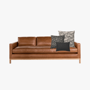 Ezra pillow combo with Magnolia, Felix, and Onyx Lumbar on a leather sofa