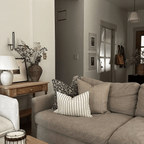 Felix, Georgia, and Winston Lumbar on a taupe couch in a living room. 