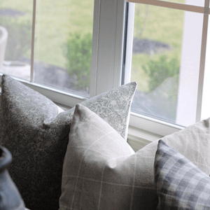 A closeup of Fitz, Wesley, and Maxwell pillows in front of a window