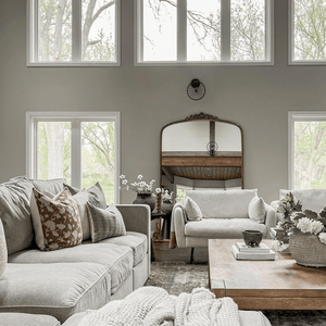 A living room with two beige couches and Florence and Blain Lumbar pillows