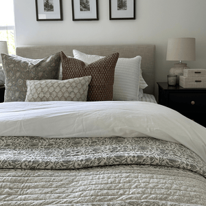 A bed with a gray headboard and Kennedy, Emery, and Jade Lumbar from Colin + Finn