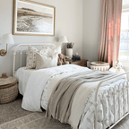 Leighton and Laney Lumbar on a little girl's bed with cream bedding and a painting behind the bed