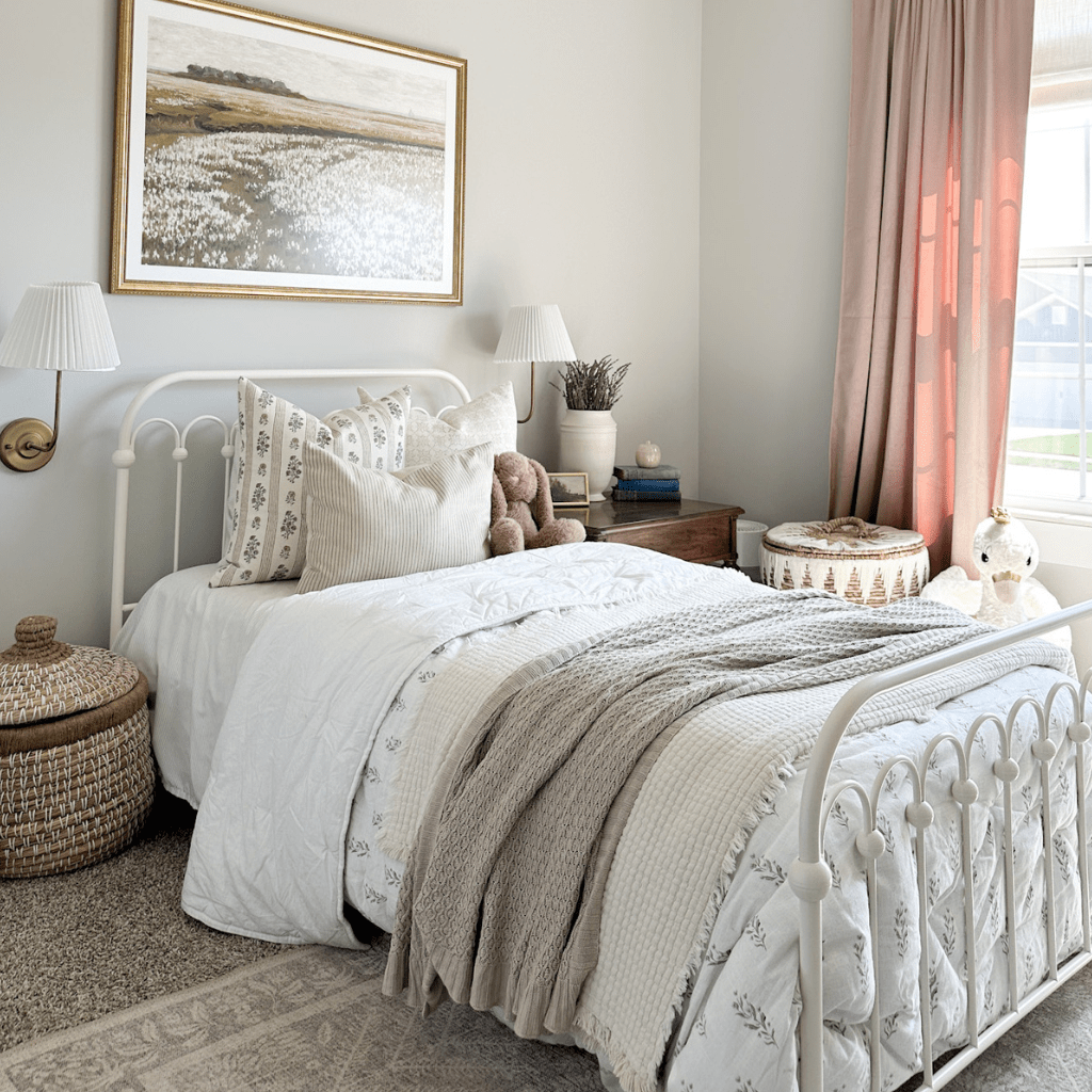 Leighton and Laney Lumbar on a little girl's bed with cream bedding and a painting behind the bed