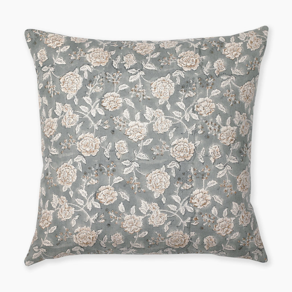 A square pillow with a light blue-green background features an intricate pattern of white and beige roses with green leaves and small brown branches. The floral design is spread evenly across the entire surface of the pillow.