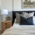 Magnolia, Felix, and Onyx lumbar throw pillows from Colin and Finn on white bed with black headboard.