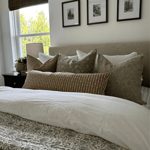 A bed with a gray headboard and Matilda, Kennedy, Louise, and Bardot Lumbar throw pillows