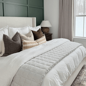Neville Mocha, Arizona, and Prescott Long Lumbar on a bed with a cream headboard in front of a green accent wall