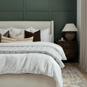 Neville Mocha, Arizona, and Prescott Long Lumbar on a bed with a cream headboard in front of a green accent wall