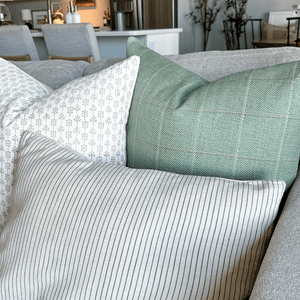 A close up of Odette, Allister, and Laney Lumbar in the corner of a grey sofa