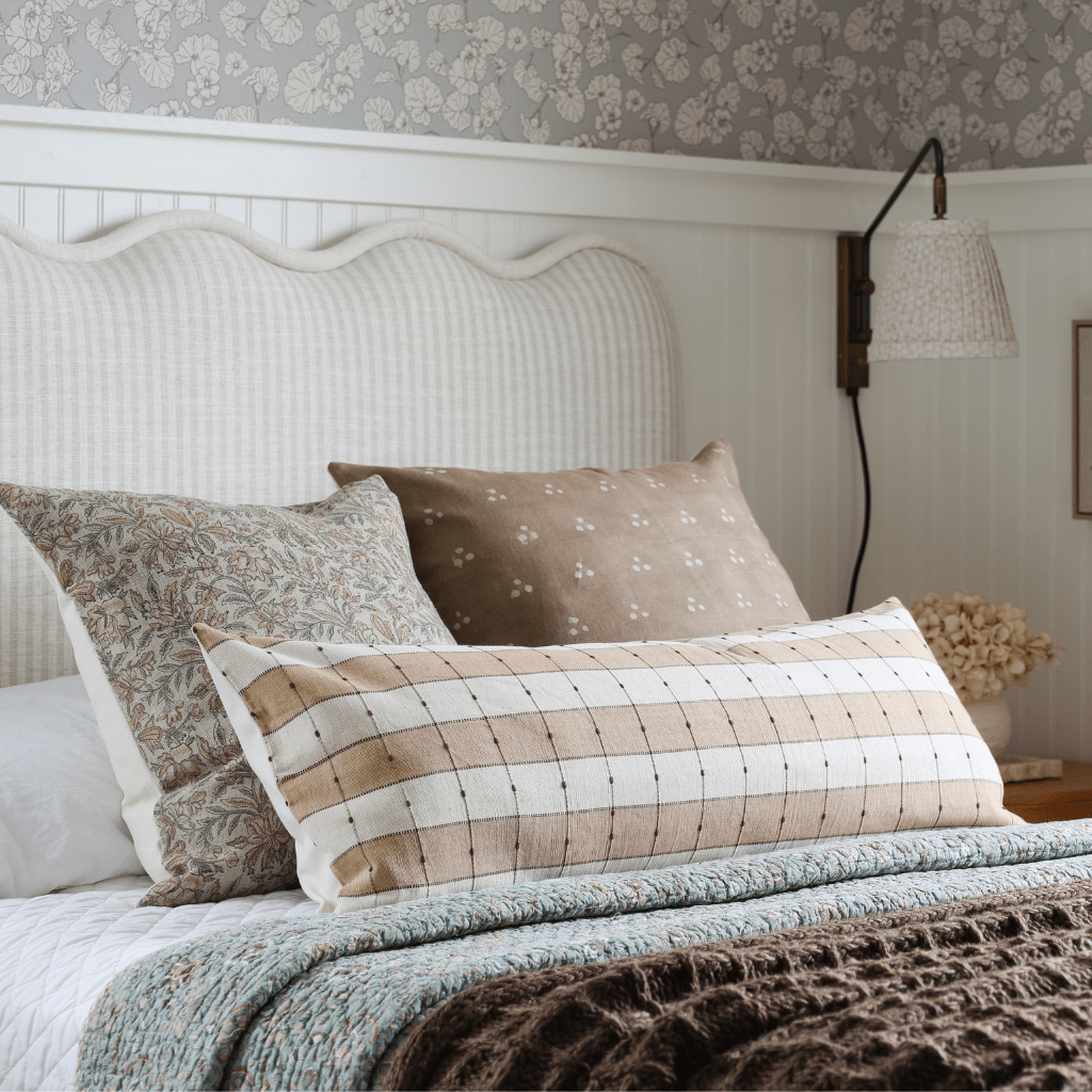 Prescott, Elain, and Emberly on a bed with a white headboard and a blue and brown blanket