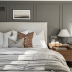 Bedroom view of the Stevie pillow combination on a white bed with green accent wall and photo above the bed.