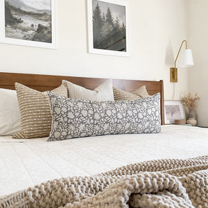 Bardot pillow covers on bed with Laney and gray sawyer long lumbar with an ivory quilt and home decor on a nightstand
