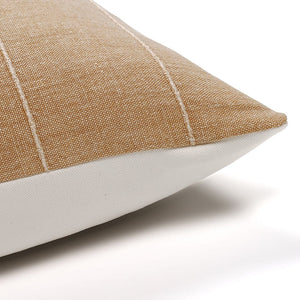 Upper corner of Dalary in camel tan pillow cover from Colin and Finn. The linen color is a camel brown with horizontal raised stripes on a white backdrop.