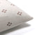 Corner of Dara pillow cover from Colin and Finn showing ivory front with rust crosses and solid ivory backing. Set on a white backdrop.