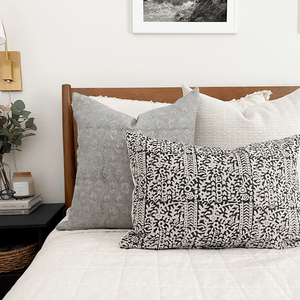 Eloise, Selma, Madison lumbar pillows from Colin and Finn on white bed with wood headboard.
