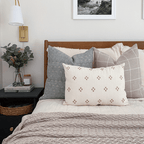 Eloise, Wesley, Dara lumbar on bed with beige blanket.