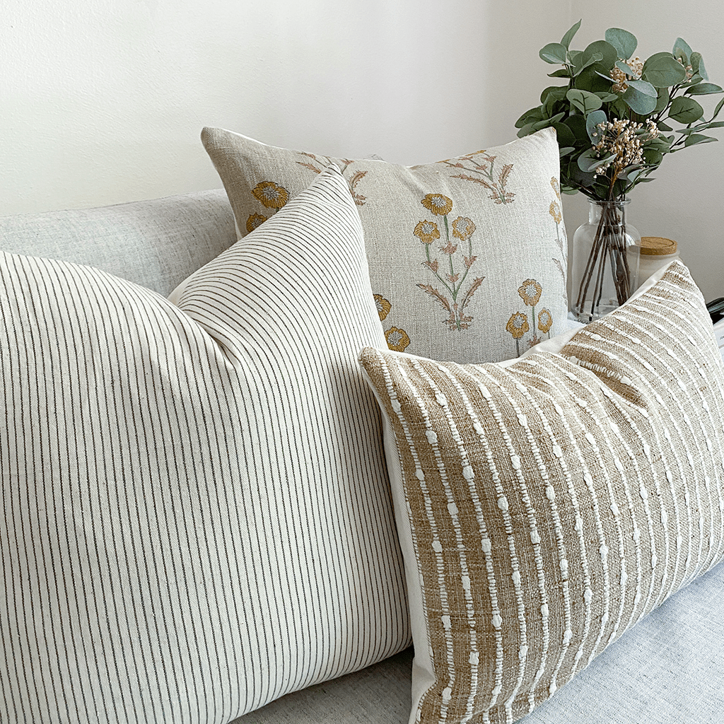 Felicity pillow combination from Colin and Finn on white sofa with floral arrangement on side table.