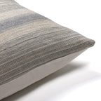 Corner of the Felicity pillow cover showing the gray handwoven stripe detail and the ivory backing