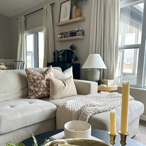 Jade, Florence, and Bardot burlap lumbar throw pillows from Colin and Finn on gray sectional. Coffee bar in background and candles in foreground.