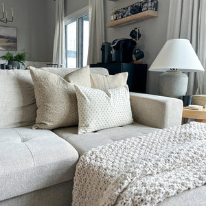 Kinsey, Neville in Sand, and Elodie lumbar pillow covers on a gray sectional with chunky taupe blanket.