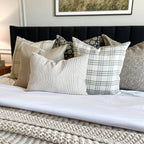 Laney lumbar, Bailey, Kinsey, and Fitz pillow sitting on a bed with light sheets and a throw blanket