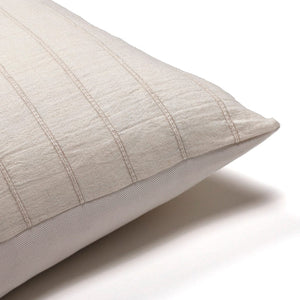 Corner of Logan pillow cover showing ivory cotton stripes and solid ivory backing.