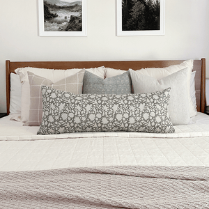 Colin and Finn's Malibu pillow combo on white bed with wood headboard and nature photos above bed.