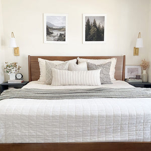 Petra pillow combination from Colin and Finn showing Avery, Selma, Madison, and Winston oversized lumbar pillow cover on white bed with wood headboard and photos above bed.