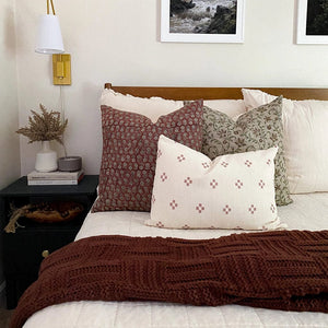 Rica pillow combination with Forrest, Serena, and Dara lumbar pillow cover on white bed with maroon throw blanket.