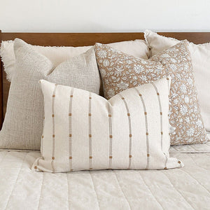 Selma, Eleanor, and Rory lumbar pillow covers from Colin and Finn on white bed with cognac wood headboard and white wall.