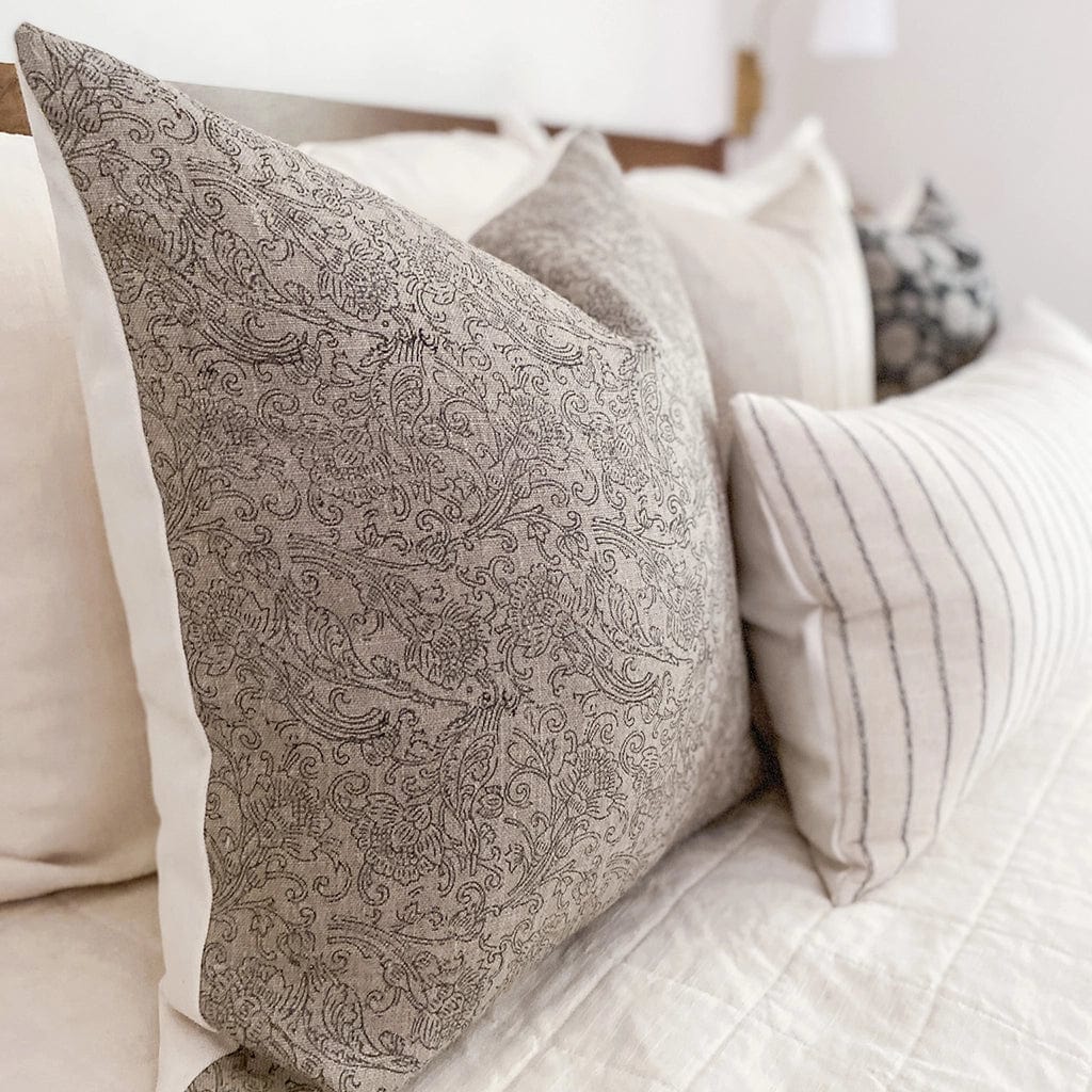 Side view of Fitz pillow cover showing linen background and black floral print.