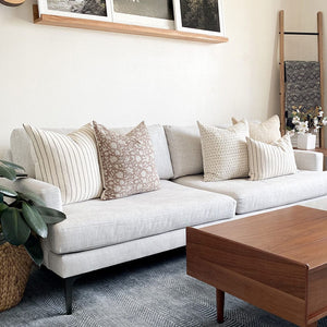 Winston, Eleanor in natural, Weston, Luella, and Winston lumbar on white couch with wood coffee table.
