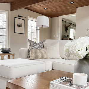 Conyer pillow combination from Colin and Finn on white sofa with wood panel ceiling.