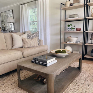 Sawyer pillow cover sitting on a beige sofa with Laney and Bardot Burlap Colin and Finn throw pillows in a living room. A light brown coffee table with books and a bowl sitting on it.